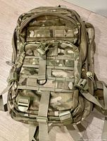 Front view of Rothco camouflage backpack showing MOLLE webbing, compression straps and overall condition