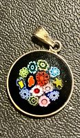 front view of round Murano millefiori pendant in silver bezel
