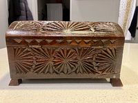 Front view showing carved patterns, hinges, and feet