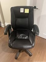 Full front view of chair showing upholstery, armrests, base