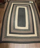 Full view of braided flatweave area rug showing concentric rectangular bands