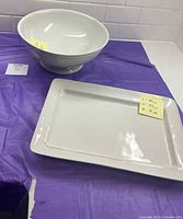 Footed serving bowl and rectangular platter on table
