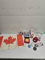 All items laid out on table including flag, dominoes tin, jumbo cards, dice, games, Rubik’s Cube, figurine