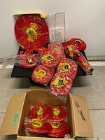 Bulk view showing all packaged red and gold lanterns on table and in box