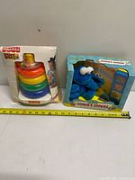 Front view of both boxed items with measuring tape for scale