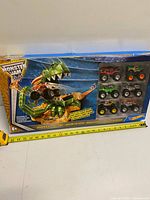 Front of sealed Dragon Blast Challenge box with window showing 6 trucks, tape measure for scale