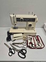 Full view of sewing machine, pedal, cord, scissors, button packet