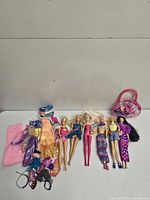Overview of six Barbie dolls, clothing pile, accessories and tote bag