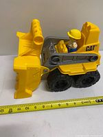 Left side view showing bulldozer profile, scoop lowered, tape for scale