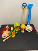 Group shot showing both push toys, bead maze, and full food cutting set
