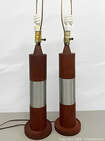 Front view of both teak cylinder lamps showing full height with harps and bulbs