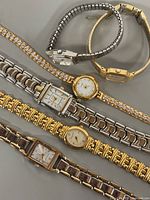 Six ladies’ wristwatches laid out to show fronts and bracelets