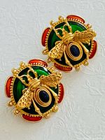 Front view showing green and red enamel base and gold bee motif