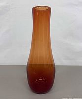 Full front view of tall amber gradient glass vase