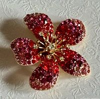 Front view showing red/pink rhinestone petals and clear center stones