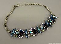 Full view of necklace laid flat showing design and stones