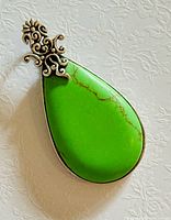 Front view of teardrop gaspéite brooch showing stone color and scroll top