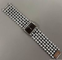 Front view showing black dial, rectangular case and six-row rounded-link bracelet