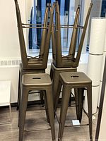 Eight stacked brushed metal bar stools showing design and finish