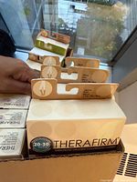 Close view inside box showing TheraFirm 20–30 mmHg packages and cardboard inserts
