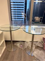 Shows both glass top cruiser tables with steel pedestals