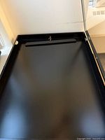 Interior of first black jersey display case showing hanger bar, gas strut and latch