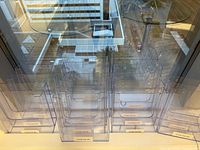 All 16 acrylic brochure racks on a windowsill showing translucency and uniform size