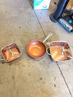All three Copper Chef pans and two lids arranged on floor
