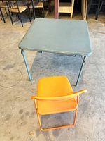 Table and chair set up on floor, showing size and colors