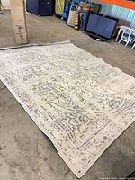 Full view of rectangular cream and grey rug laid flat on floor