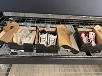 Overview of three pairs of toddler Jordan sneakers each in black Jordan boxes on shelving