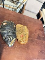 Tan and black Rawlings gloves on table