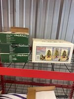 Box of 12 Noel cooler glasses and three green boxes of salad plates on shelf