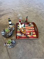 Lot overview showing tray, planters, lighthouses, glass hurricane, bell, boat model, plaque and accents