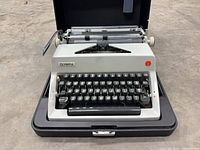 Front view of Olympia De Luxe typewriter seated in open hard case
