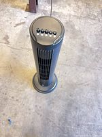 Full view of oscillating tower fan standing upright on floor