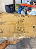 Front of box showing Real Flame branding, mantel line drawing, model Sime and white color information