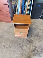 Front view of side table showing open shelf and drawer