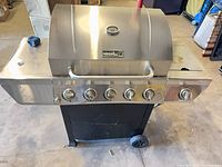 Front view of Nexgrill stainless propane grill showing six control knobs and cart base