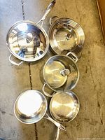 Overhead view of all five pots/pans with three lids