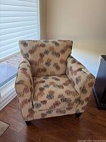 Front view of armchair showing fabric pattern, arms and legs