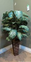 Full view of artificial Dieffenbachia in tall wood vase