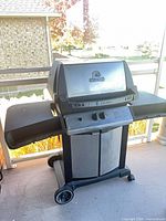 Front angled view showing full Broil King Crown grill with side shelves and wheeled base