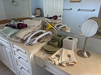 Overall lot on bathroom counter showing towels, grab bars, hair dryer, accessories and mirror