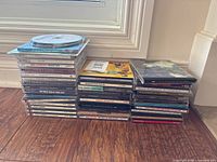 Two stacks of assorted CDs and loose discs