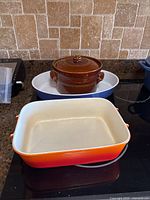 All three baking dishes displayed on stovetop for size and color comparison