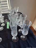 Group of cut crystal champagne flutes, rocks glasses and goblets on table
