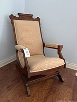 Front view of Eastlake platform rocker showing upholstery and wood frame