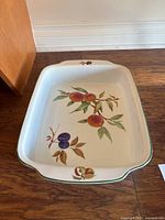 Top angled view of baking dish showing fruit motif and green rim