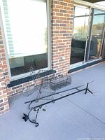 Plant stand, wall scroll panel, planter basket and pole base on patio floor